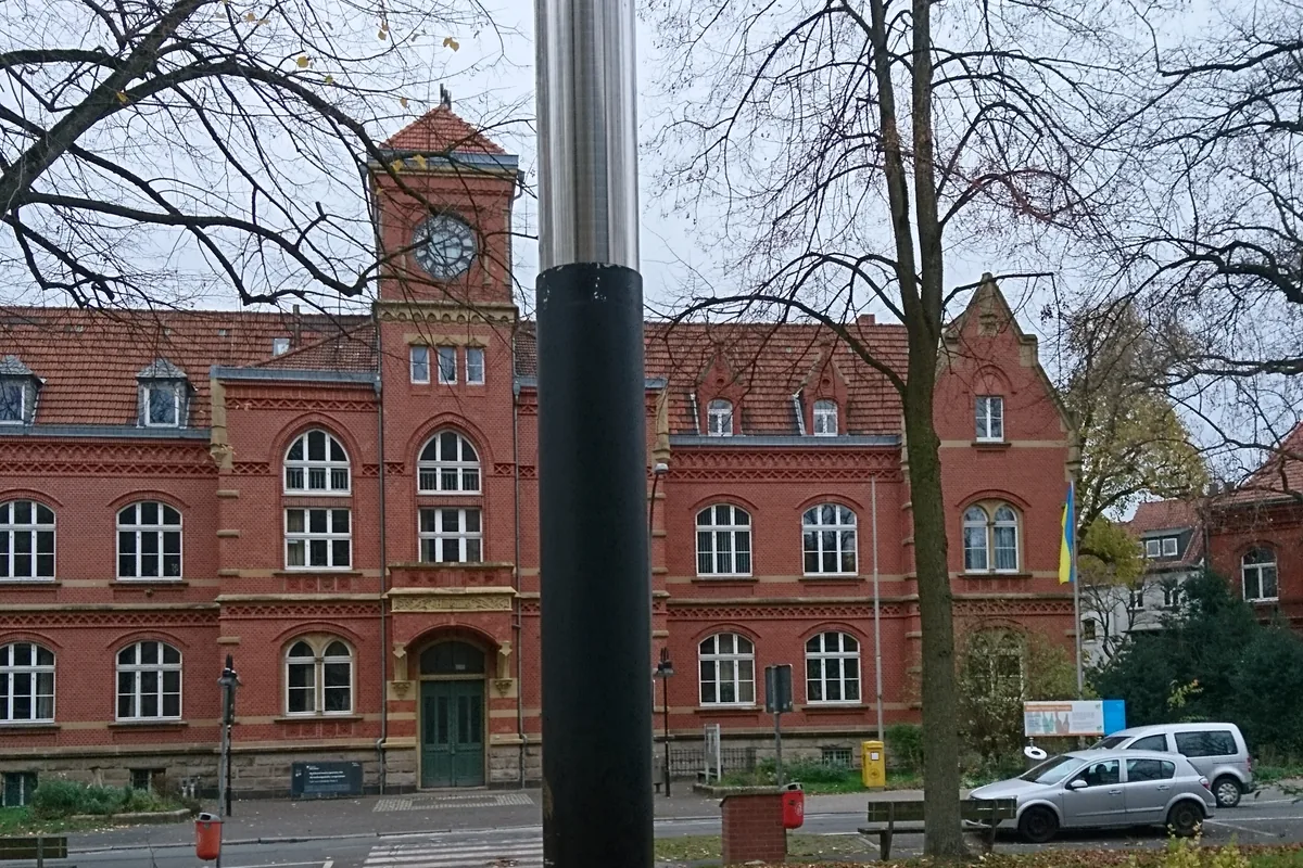 Blick über den Carl-von-Ossietzky-Platz mit der Edelstahl-Säule auf das Amtshaus Langendreer im Herbst